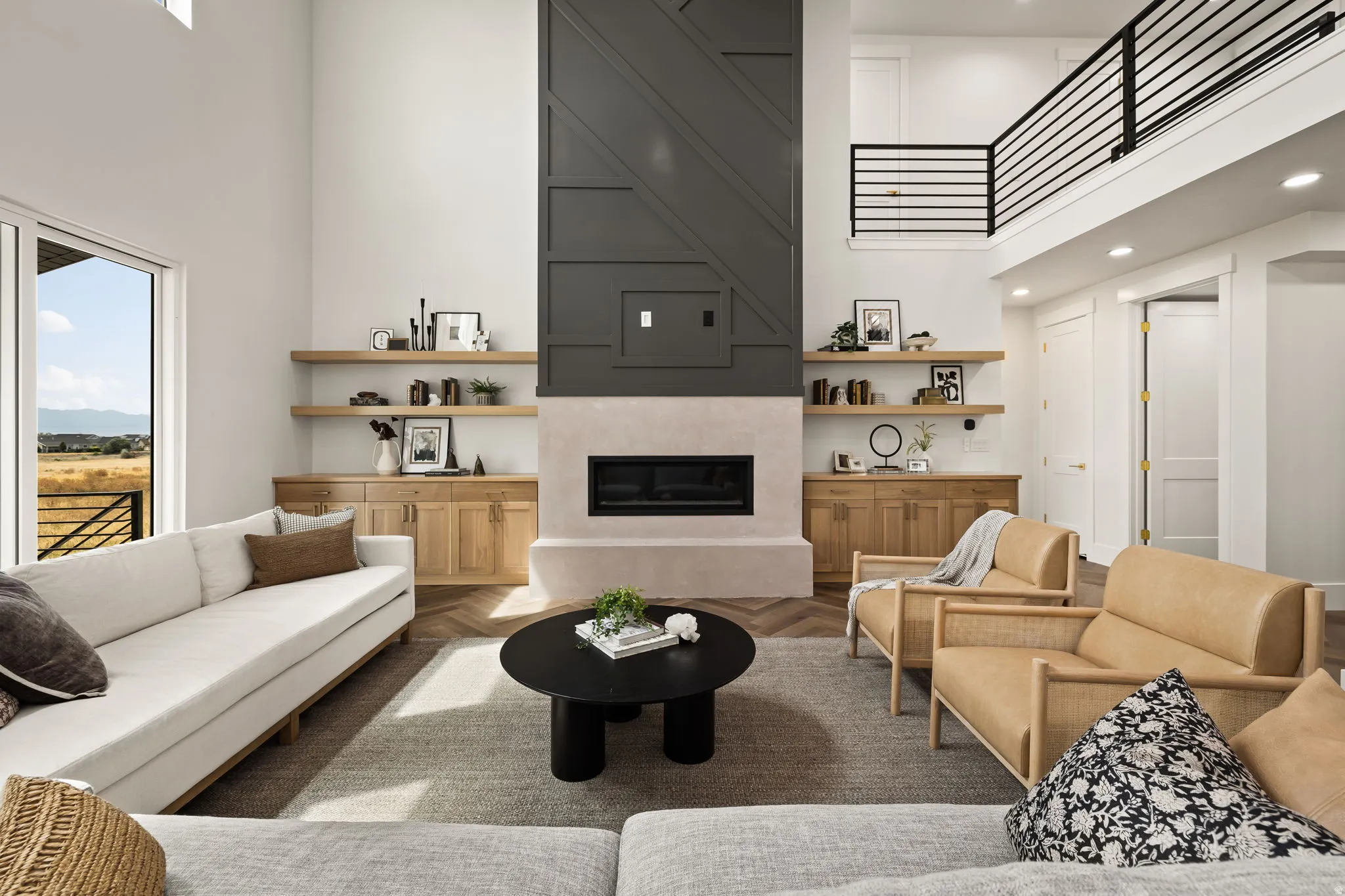 Living area with high ceilings and a prominent fireplace featuring a textured surround and a dark accent wall