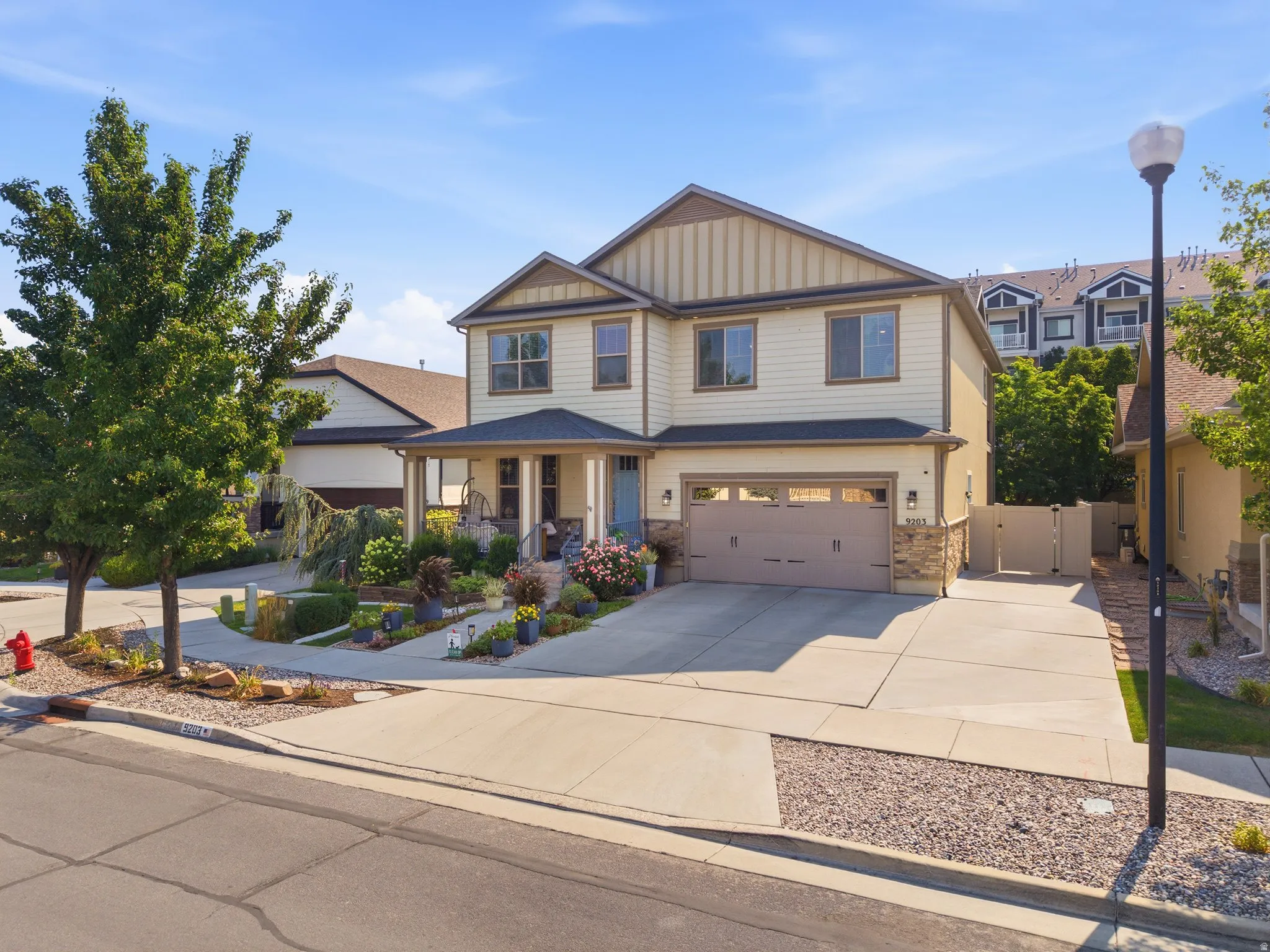 Two-story residence featuring light-toned siding, a covered front porch, and a two-car garage