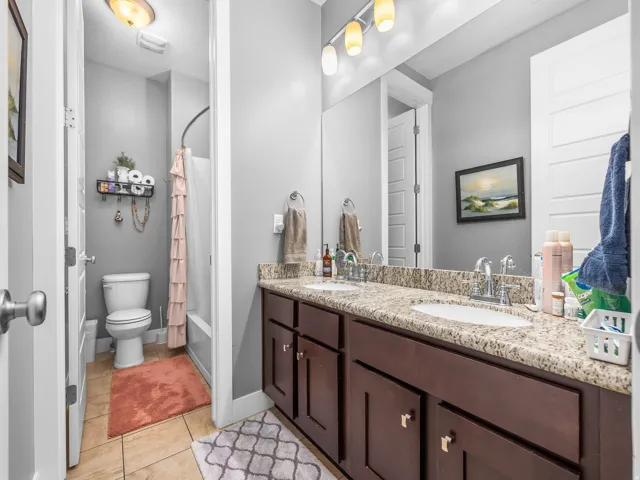 Dual vanity with granite-style countertop and dark wood-finish cabinetry