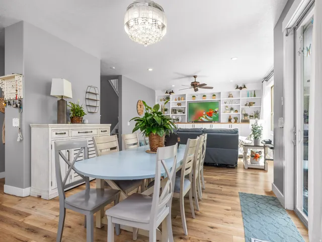 Open-concept living area with wood-finish flooring, recessed lighting, and a crystal chandelier