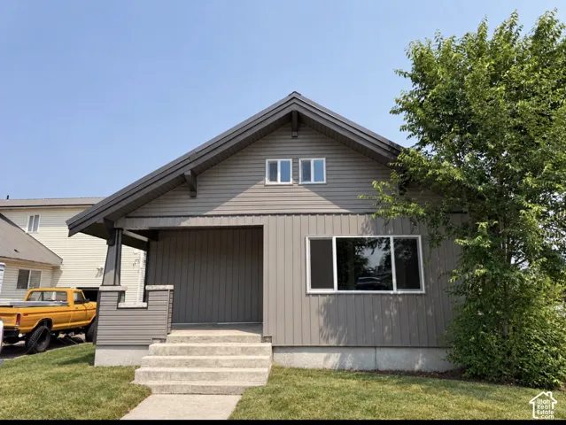 Craftsman-style home featuring horizontal and vertical siding, a covered entry, a gabled roofline, and multiple window types