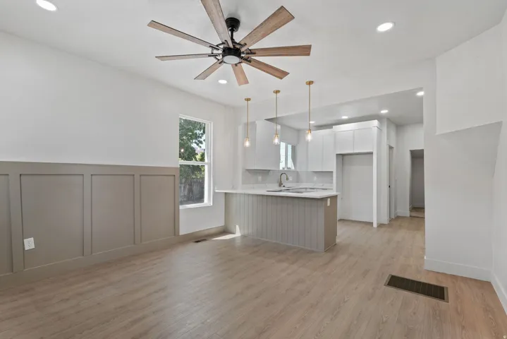 Open-concept space featuring wood-finish flooring, a contemporary ceiling fan, and recessed lighting
