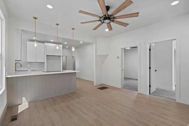 Open concept living space featuring wood-finish flooring, a contemporary ceiling fan, and recessed lighting