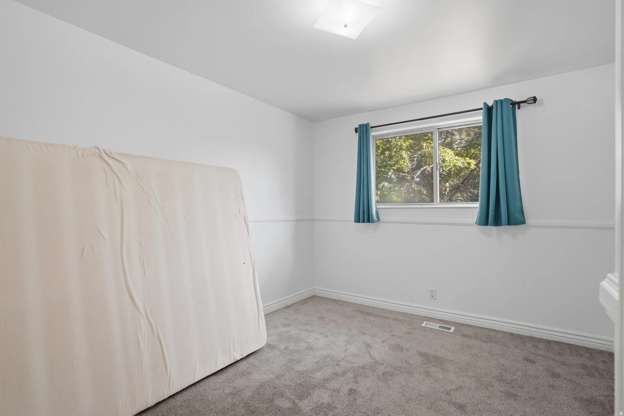 Carpeted room featuring a double-paned window with natural light, white painted walls, and white trim molding