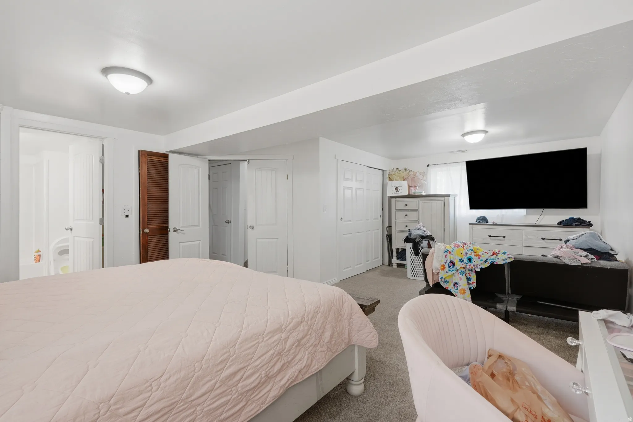 Spacious room featuring carpet flooring, white walls, and two ceiling-mounted dome lights