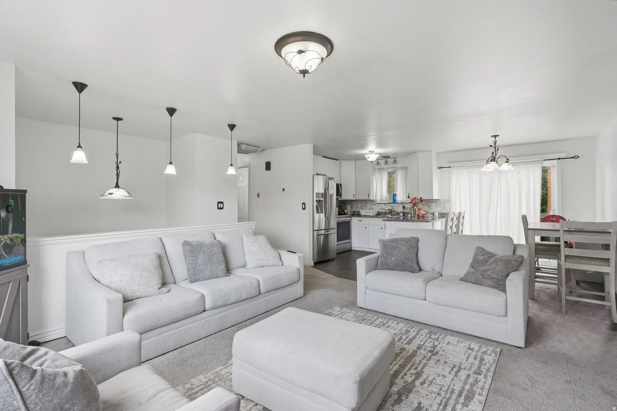 Open concept living space featuring recessed lighting and neutral-toned carpeting
