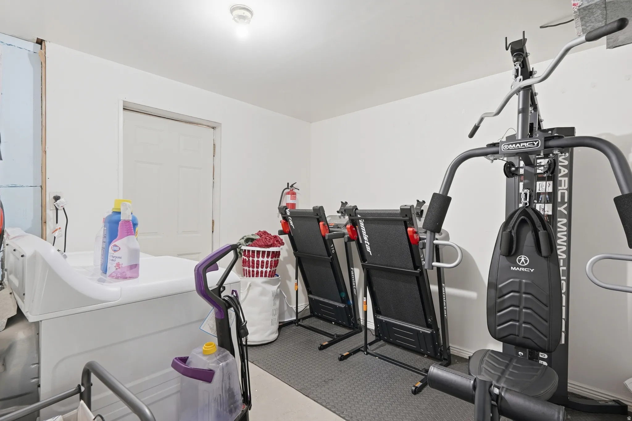 Dedicated fitness space featuring rubberized flooring and a paneled door