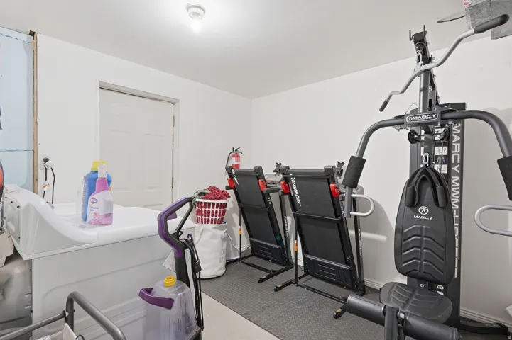 Dedicated fitness space featuring rubberized flooring and a paneled door