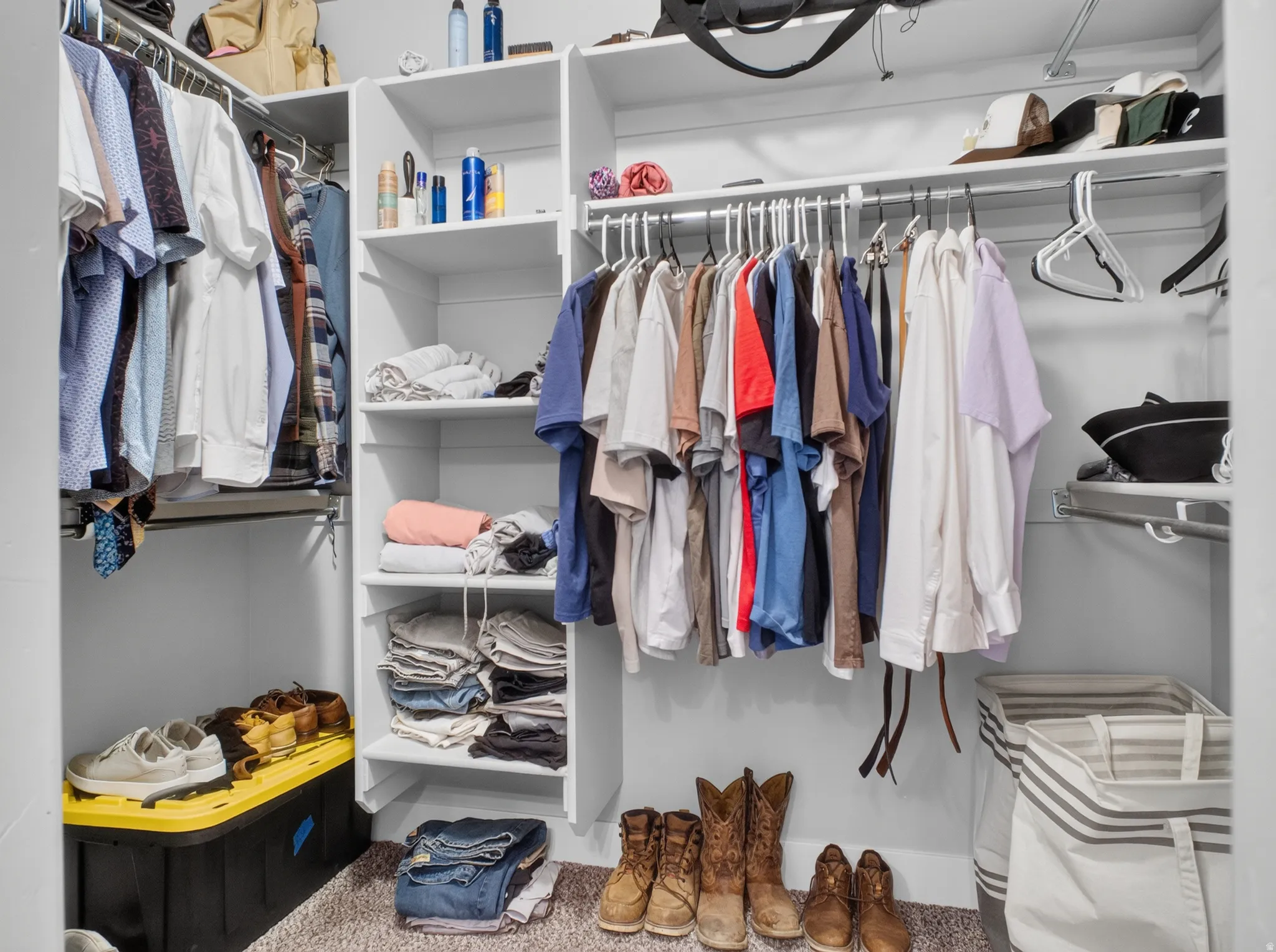 Expansive walk-in closet featuring white built-in shelving, multiple hanging rods, and an integrated wire shelving system