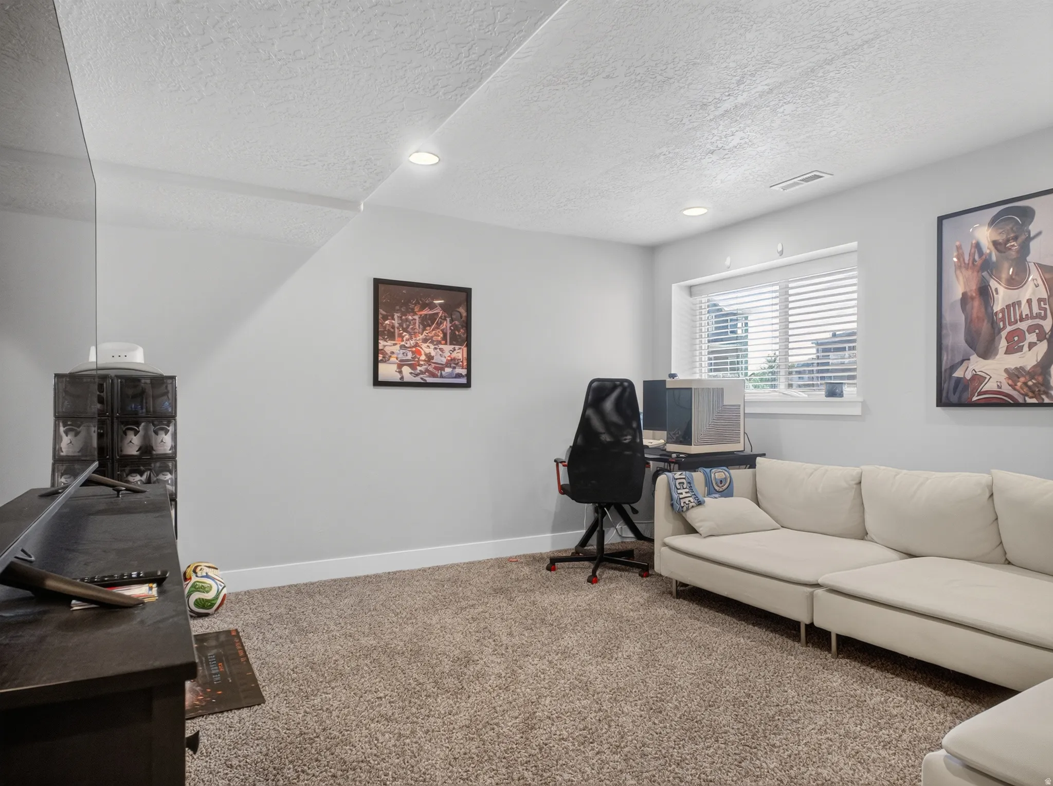 Carpeted living space with recessed lighting and a window featuring blinds