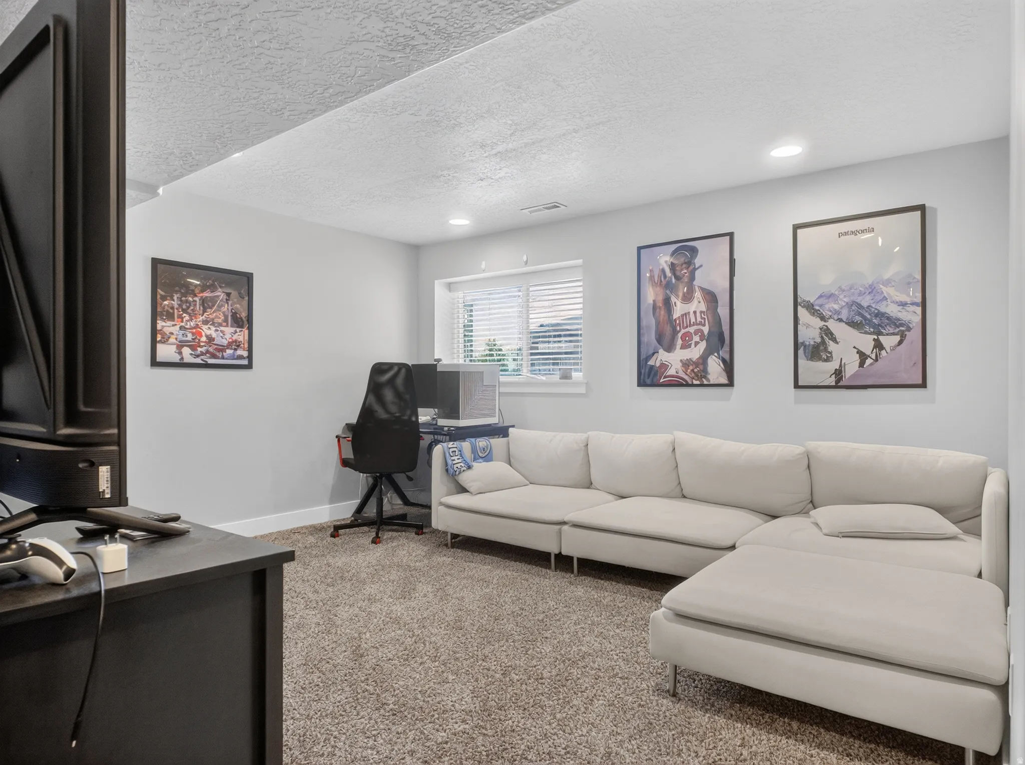 Carpeted room with recessed lighting and a window featuring horizontal blinds