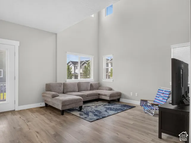 Spacious living area featuring a vaulted ceiling and wood-finish flooring