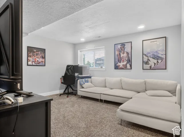 Carpeted room with recessed lighting and a window featuring horizontal blinds