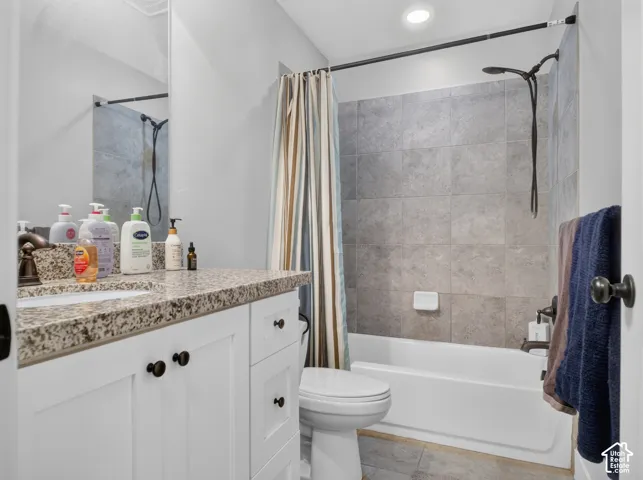 Bathroom featuring a white vanity with a speckled countertop, a drop-in sink, and dark bronze hardware