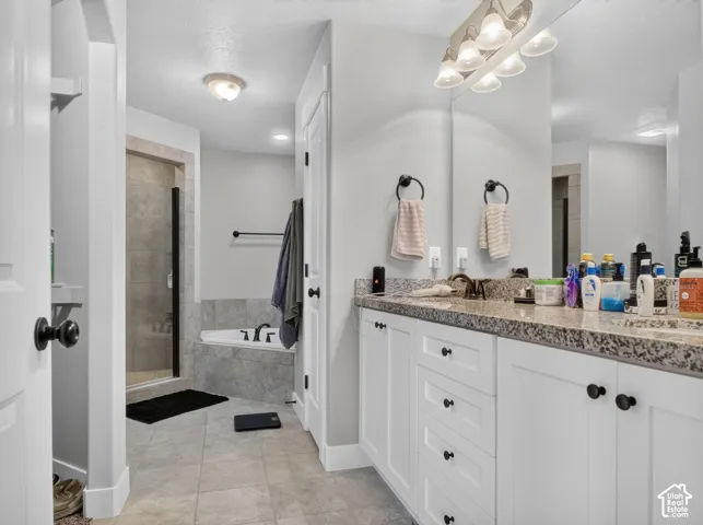 Bathroom featuring a double vanity with white cabinetry and a speckled countertop