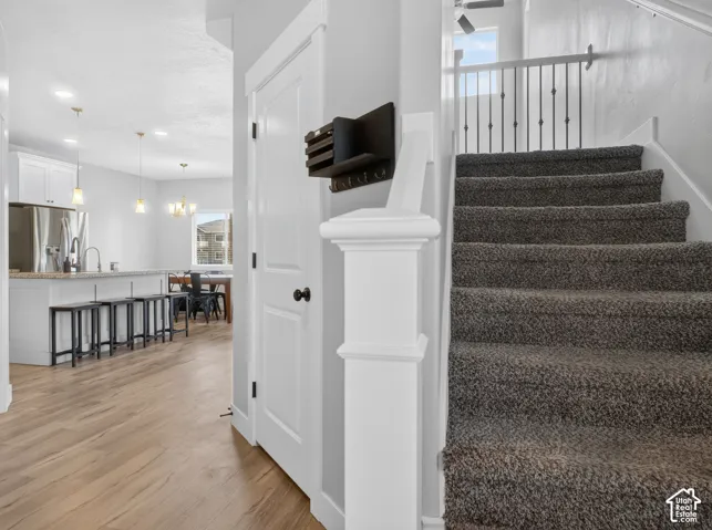 Carpeted staircase with white balusters and wrought iron spindles