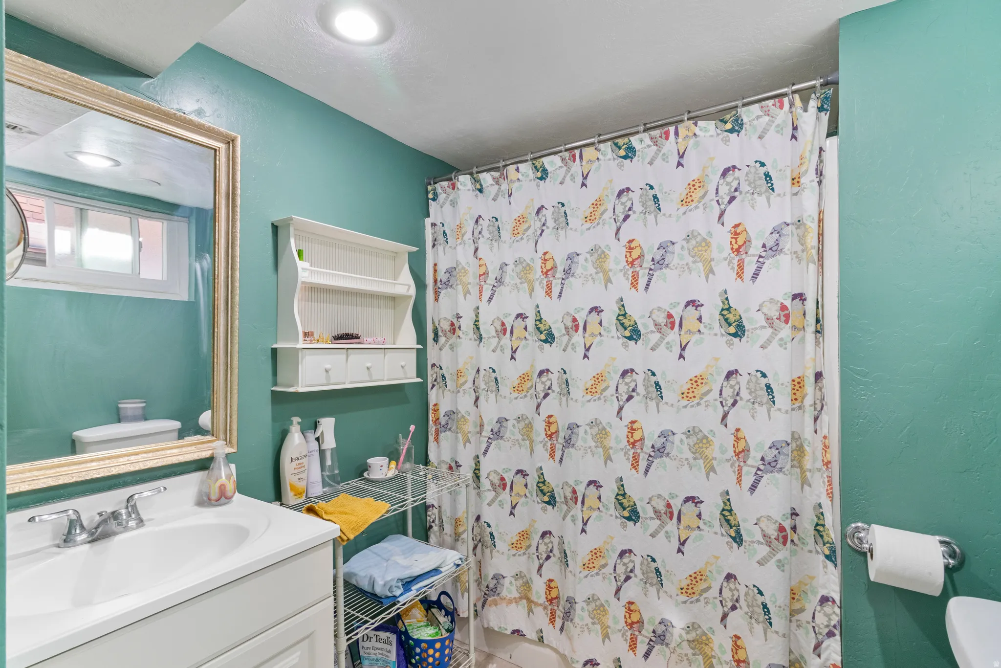 Bathroom featuring a single vanity with a white basin sink and chrome faucet