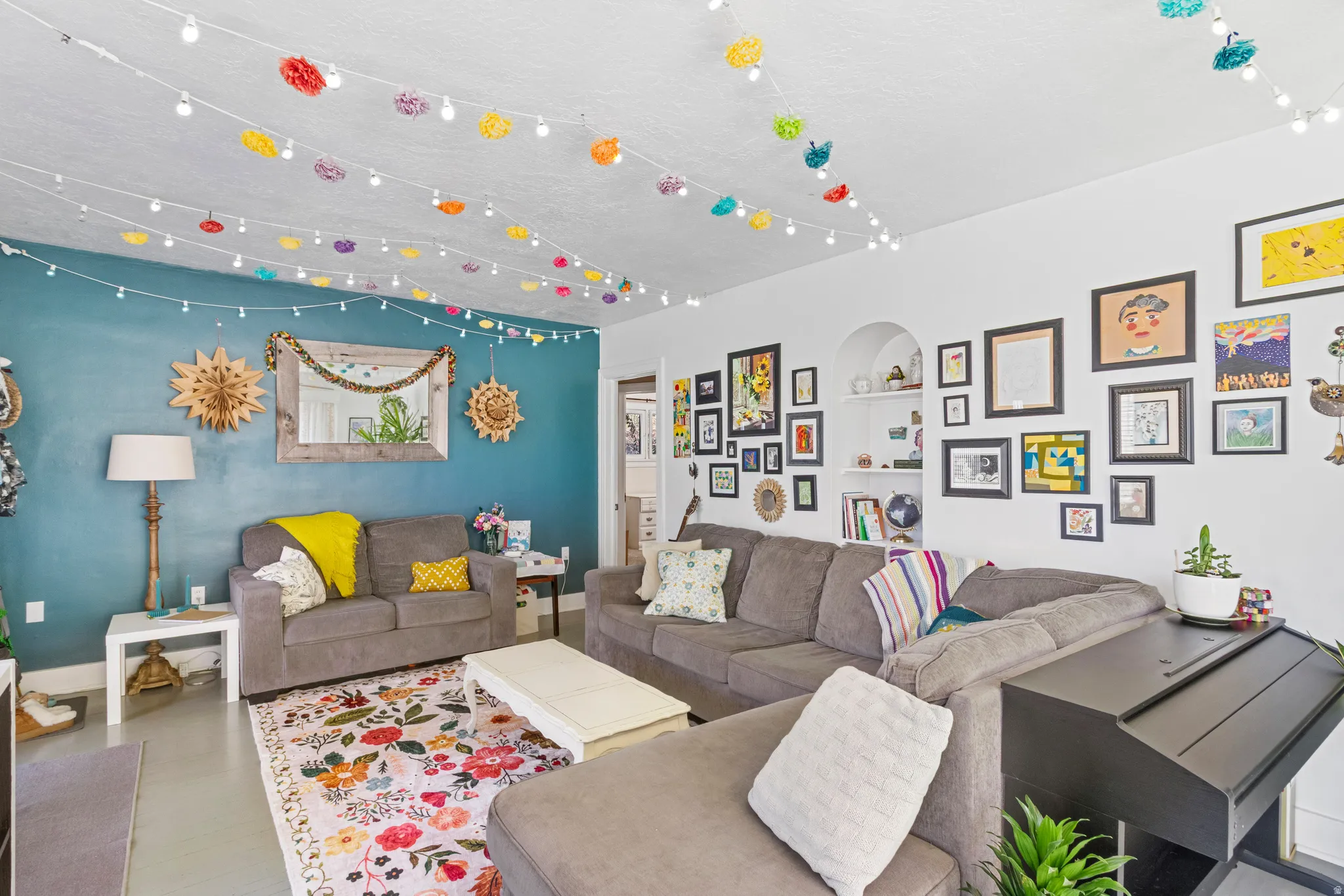 Living area featuring a distinctive accent wall, recessed shelving, and light-toned flooring