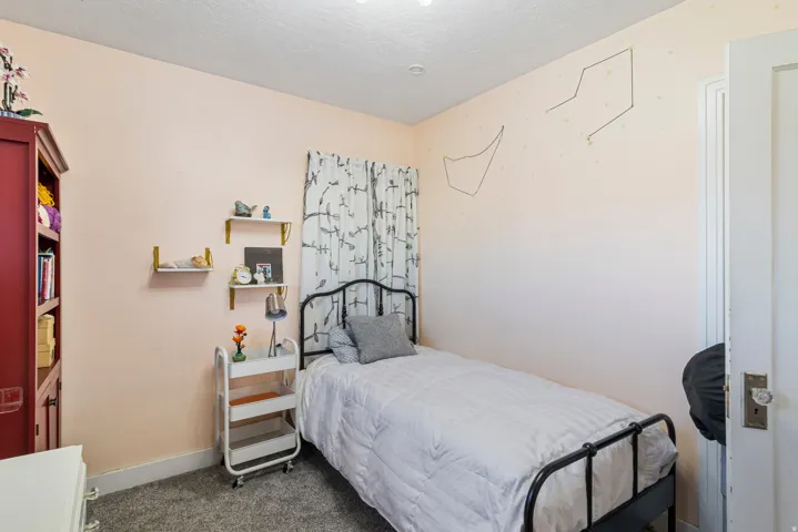Room with textured light-colored walls and grey carpet flooring