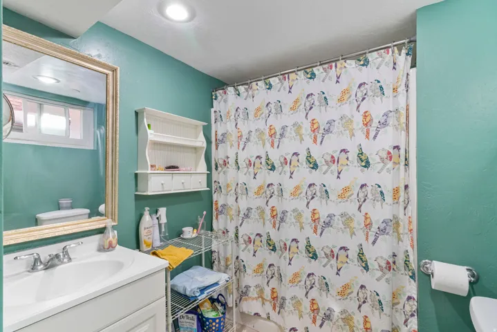 Bathroom featuring a single vanity with a white basin sink and chrome faucet