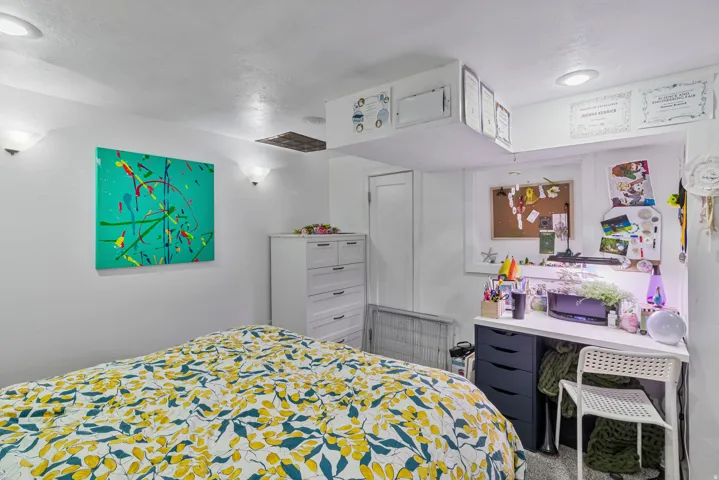 Recessed ceiling lighting and wall-mounted sconces illuminate this space, featuring white walls and a light-toned ceiling