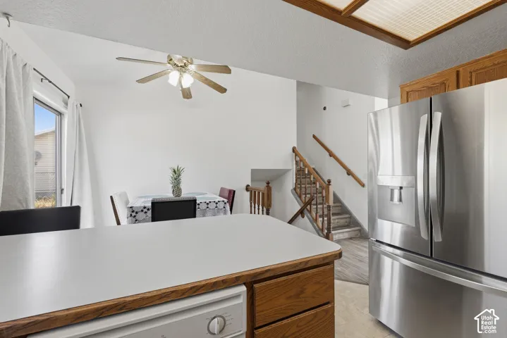 Kitchen area featuring a built-in dishwasher and a stainless steel refrigerator with an external water dispenser