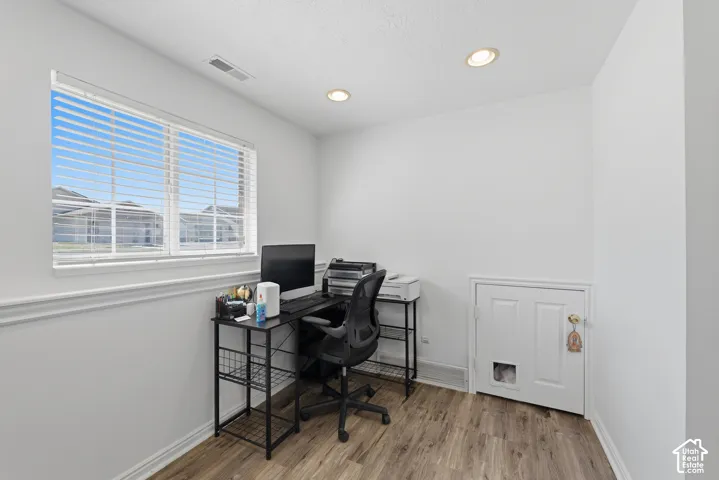 Room featuring wood-finish flooring, white baseboards, and neutral wall paint