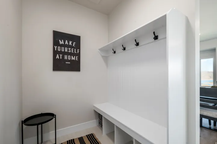 Built-in storage bench with beadboard backing, integrated coat hooks, and cubby storage