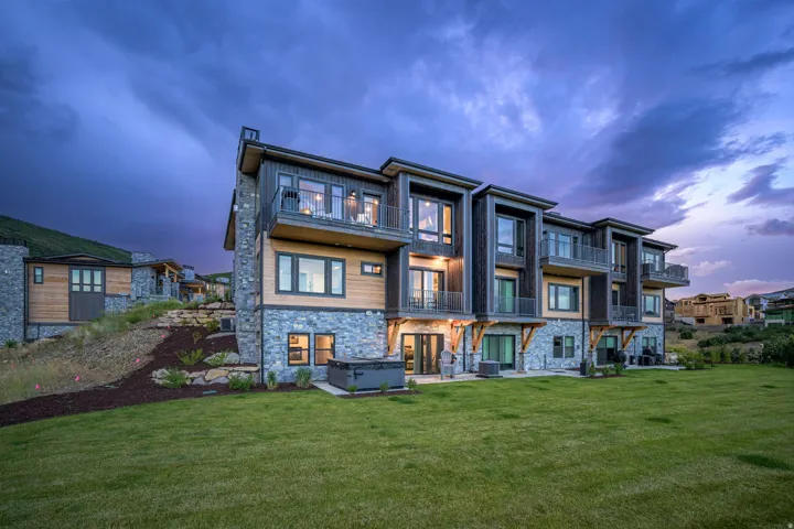 Multi-level exterior with stacked stone and wood-finish siding