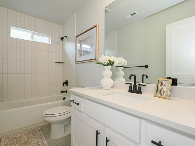 Spa-inspired bathroom featuring a white vanity with ample storage, quartz countertop, and matte black faucet hardware