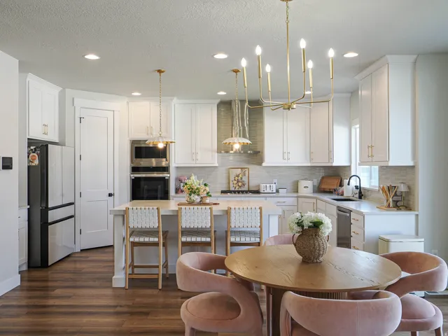 Well-appointed kitchen featuring white cabinetry, stainless steel appliances, a center island with seating, wood-finish flooring, and recessed lighting