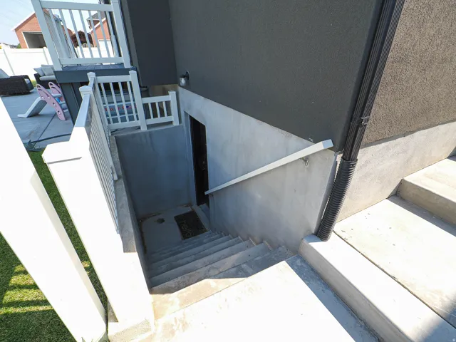 Concrete exterior stairwell with a privacy gate and metal handrails