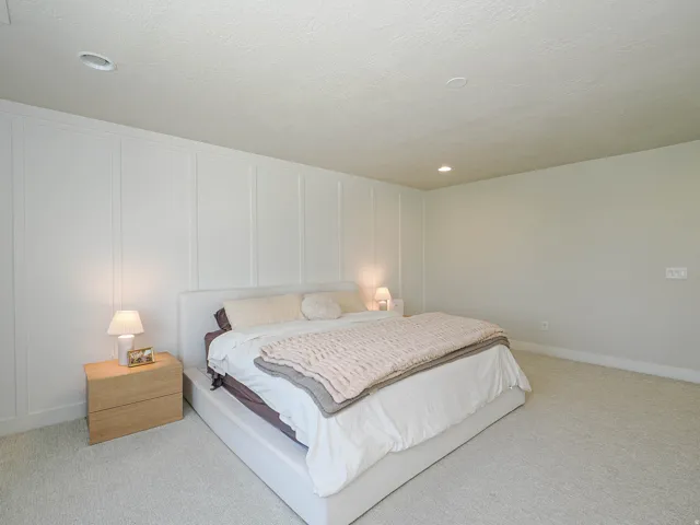 Wall paneling accent, recessed ceiling lighting, light-toned carpeting, and light-colored walls