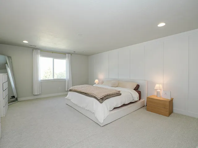 Board and batten accent wall, recessed ceiling lighting, light-toned carpeting, and a window with white drapery