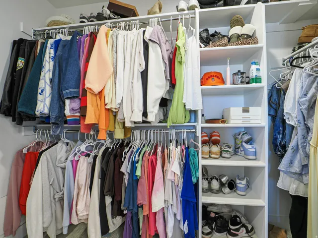 Custom closet system featuring multiple hanging rods, integrated shelving, and shoe storage