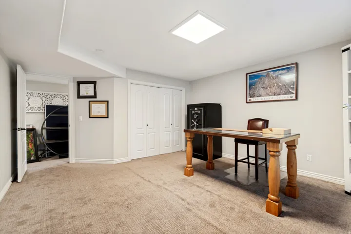 Spacious finished basement featuring neutral carpet flooring, recessed ceiling lighting, and abundant natural light from windows