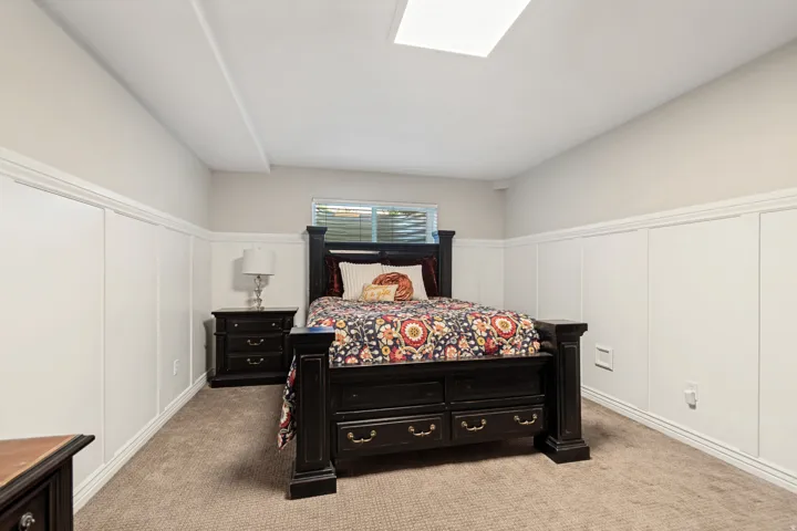Recessed ceiling light, wall paneling, and neutral carpet flooring