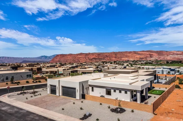 Modern industrial facility featuring clean-lined architecture with flat roofing, expansive concrete courtyard with strategic landscaping, and secure perimeter fencing
