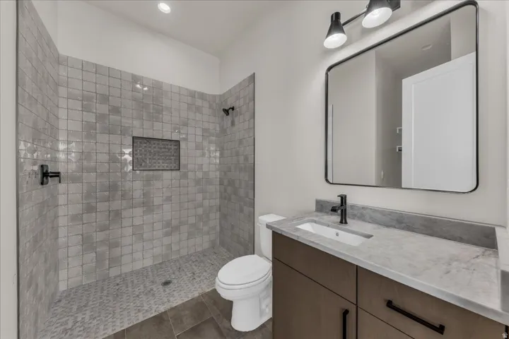 Walk-in shower with textured tile surround and recessed niche