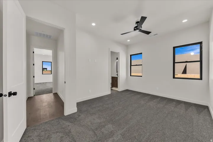 Spacious room featuring gray carpeting, recessed lighting, and a ceiling fan