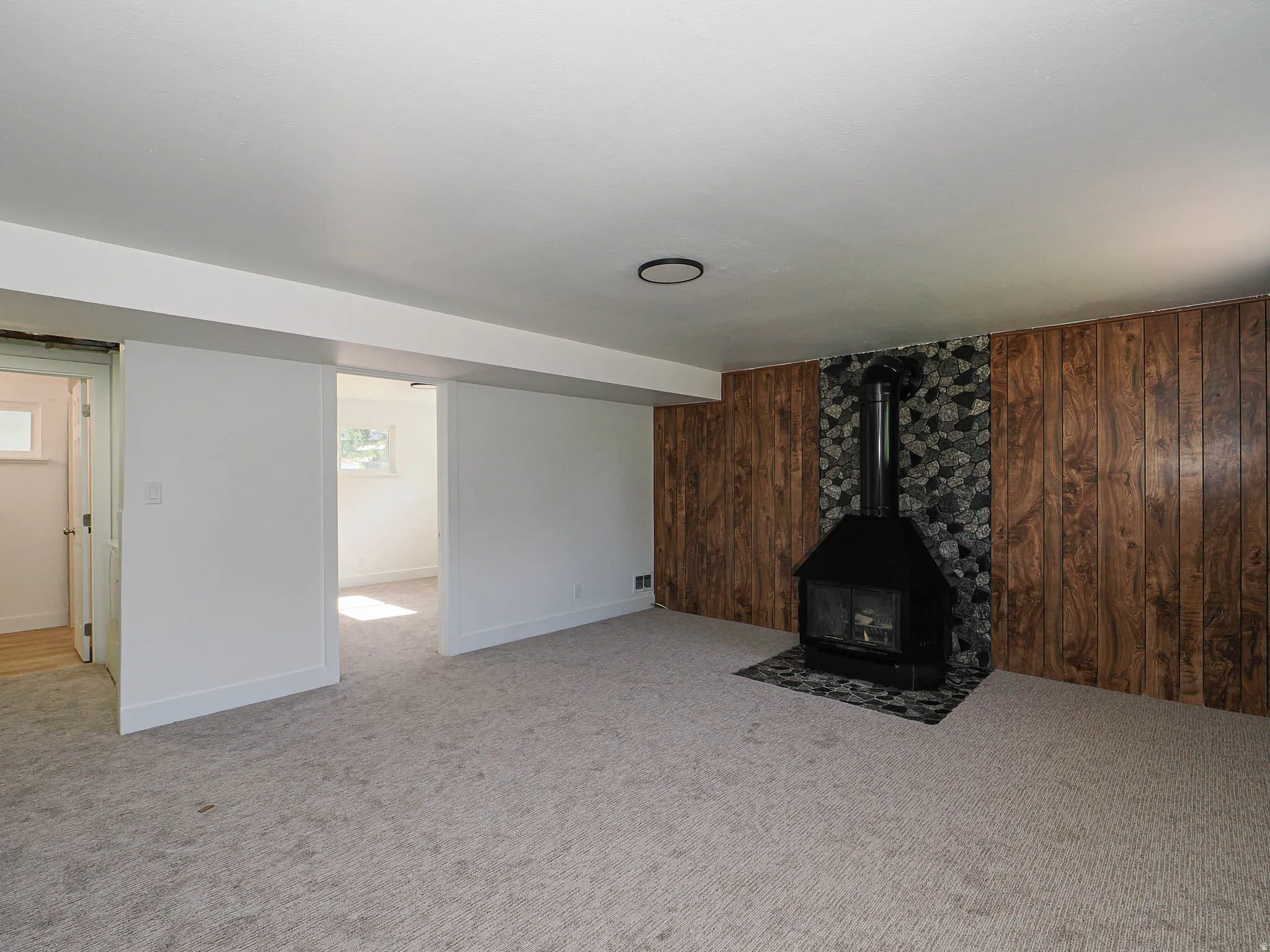 Spacious living area with neutral wall finishes and carpet flooring
