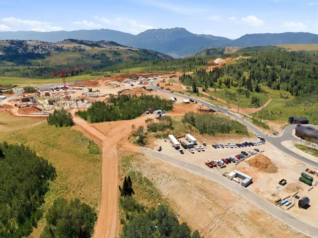 Expansive mountain landscape with diverse terrain, featuring established evergreen and deciduous tree coverage