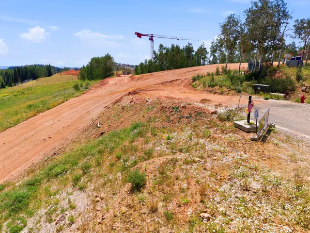 Sloping terrain with visible road infrastructure and mature trees