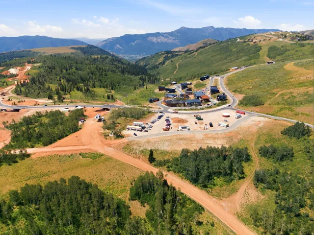 Mountainous terrain featuring developed roads, scattered residential structures, and forested hillsides