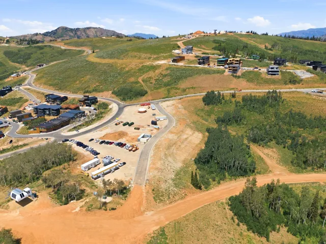 Expansive mountainous terrain featuring multiple residential structures and paved roadways