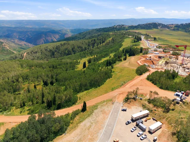 Expansive landscape featuring rolling hills and dense evergreen forests