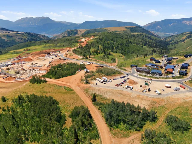 Mountainous landscape featuring development land, existing residential structures, and a new construction site