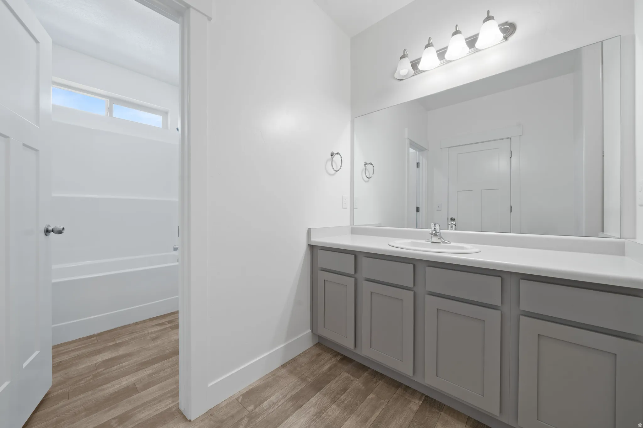 Primary bathroom - Modern vanity with gray cabinetry, white countertop, and integrated sink