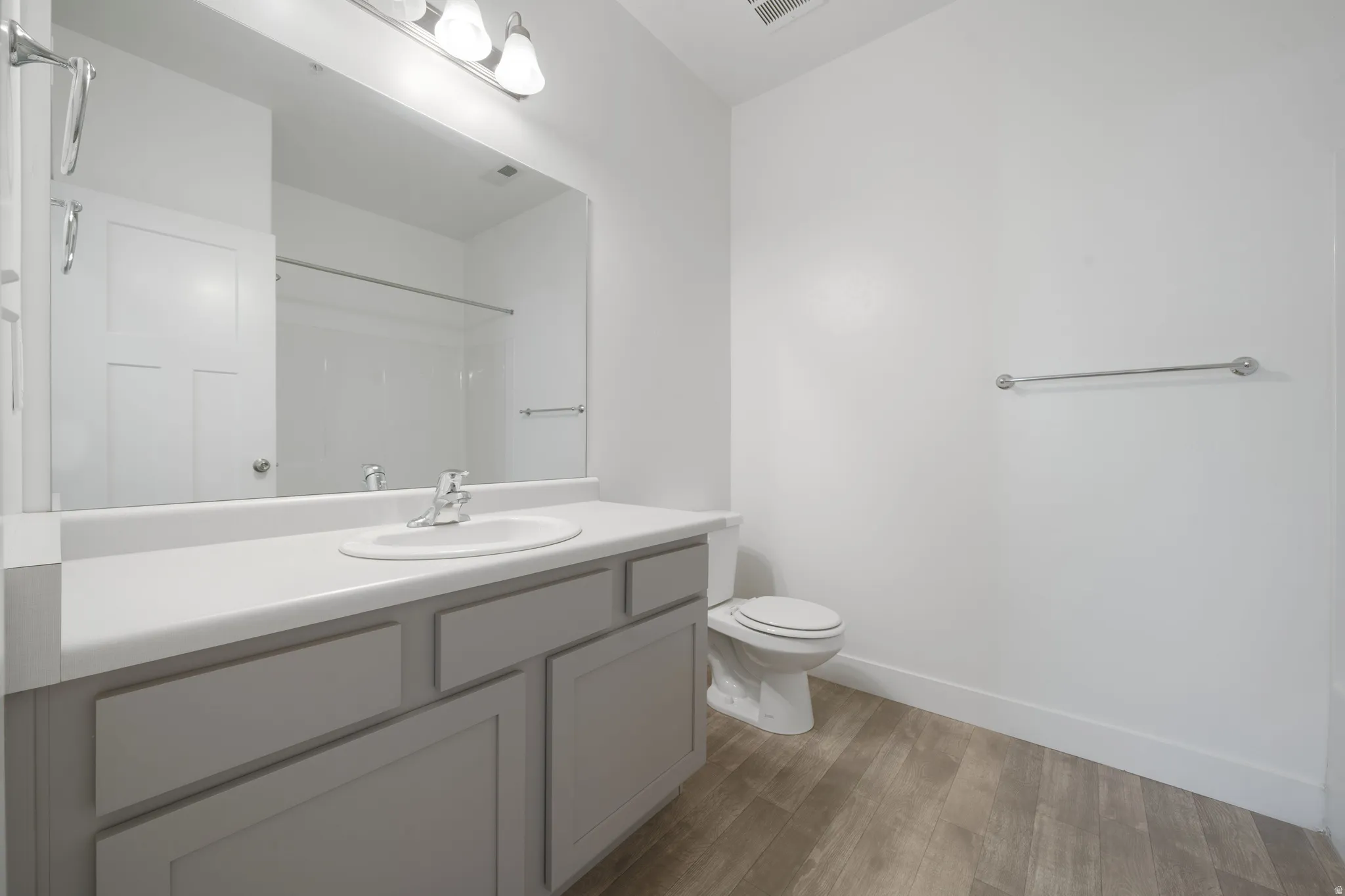 Spa-inspired bathroom featuring a double-sink vanity with gray cabinetry, white quartz countertop, and polished chrome fixtures
