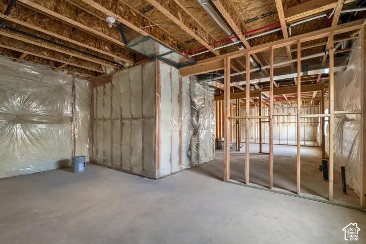 Unfinished basement with exposed ceiling joists, framed walls, and insulation